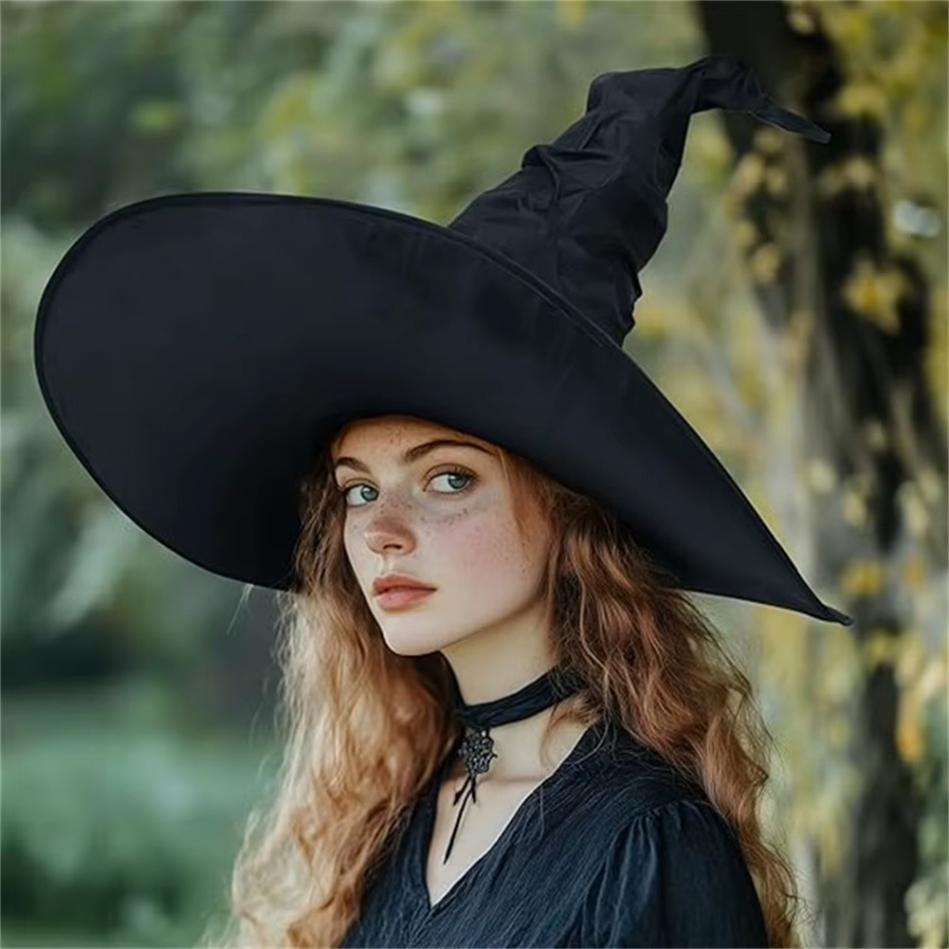 Woman wearing a black witch hat in a forest setting