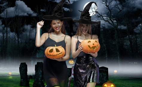 Two women in Halloween costumes holding pumpkins against a dark, eerie background with trees and tombstones.